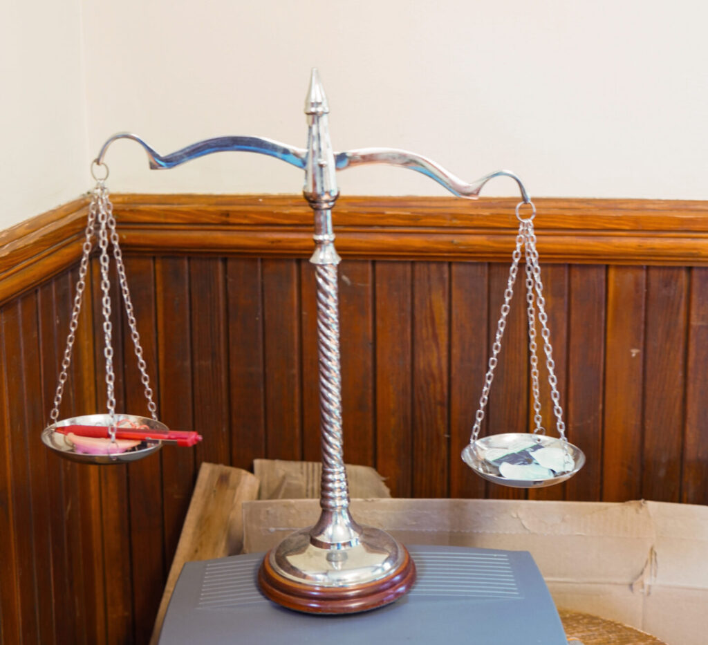 Two young professionals working together at a desk with multiple laptops and a tablet