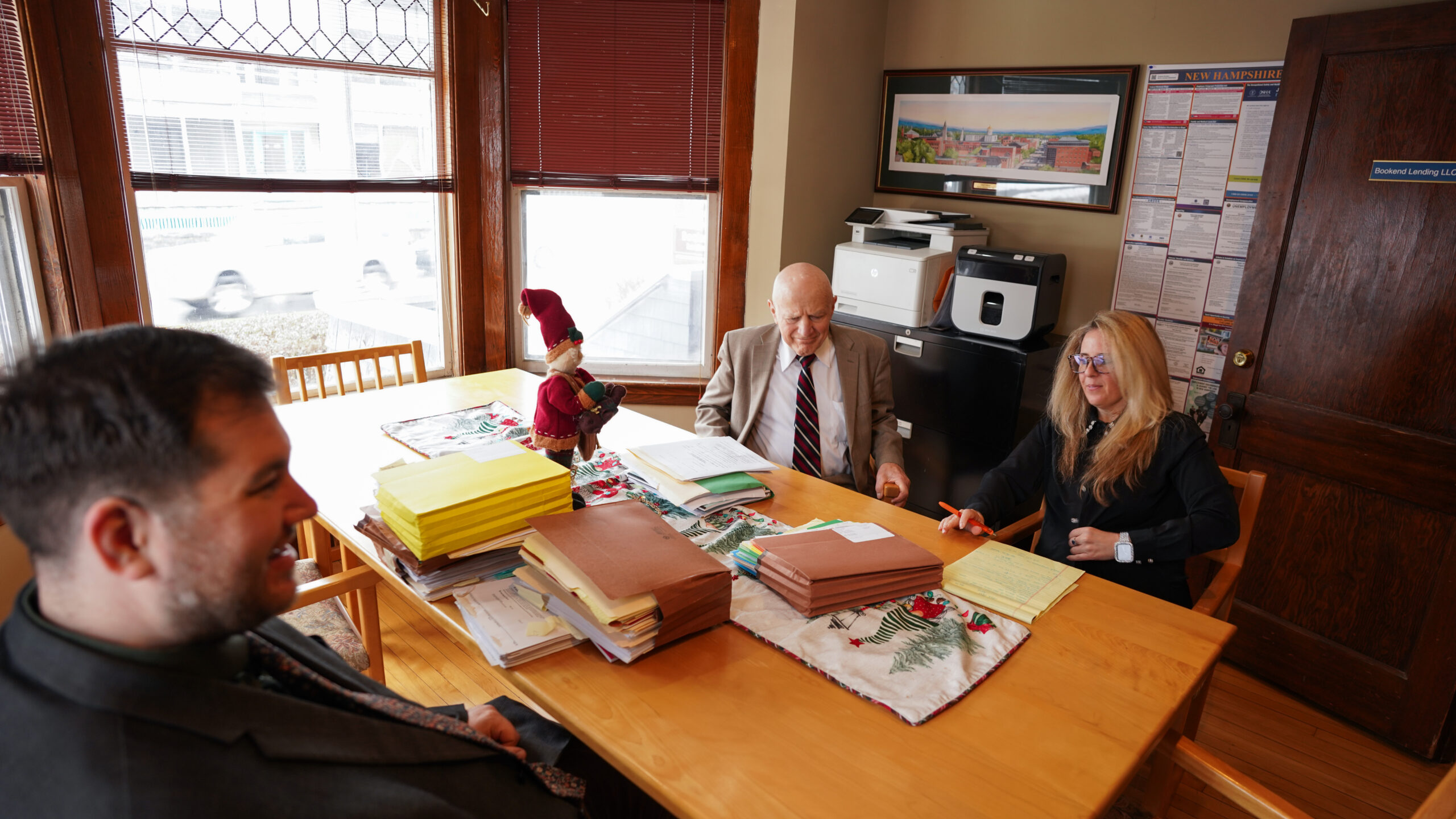 A diverse group of four professionals collaborating at a desk in a modern office.