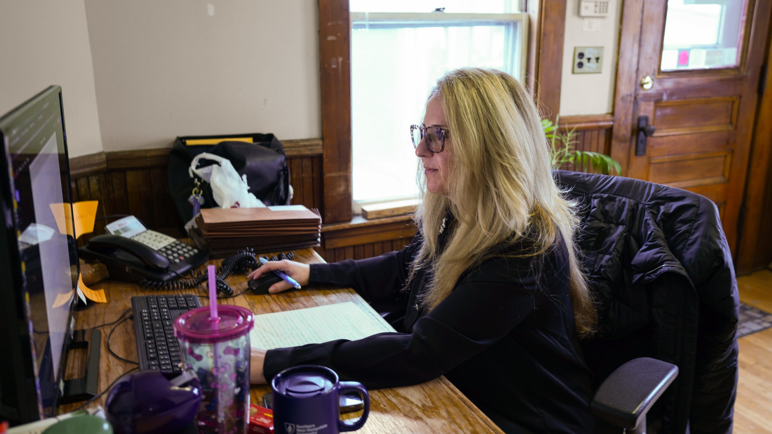 A diverse group of four professionals collaborating at a desk in a modern office.