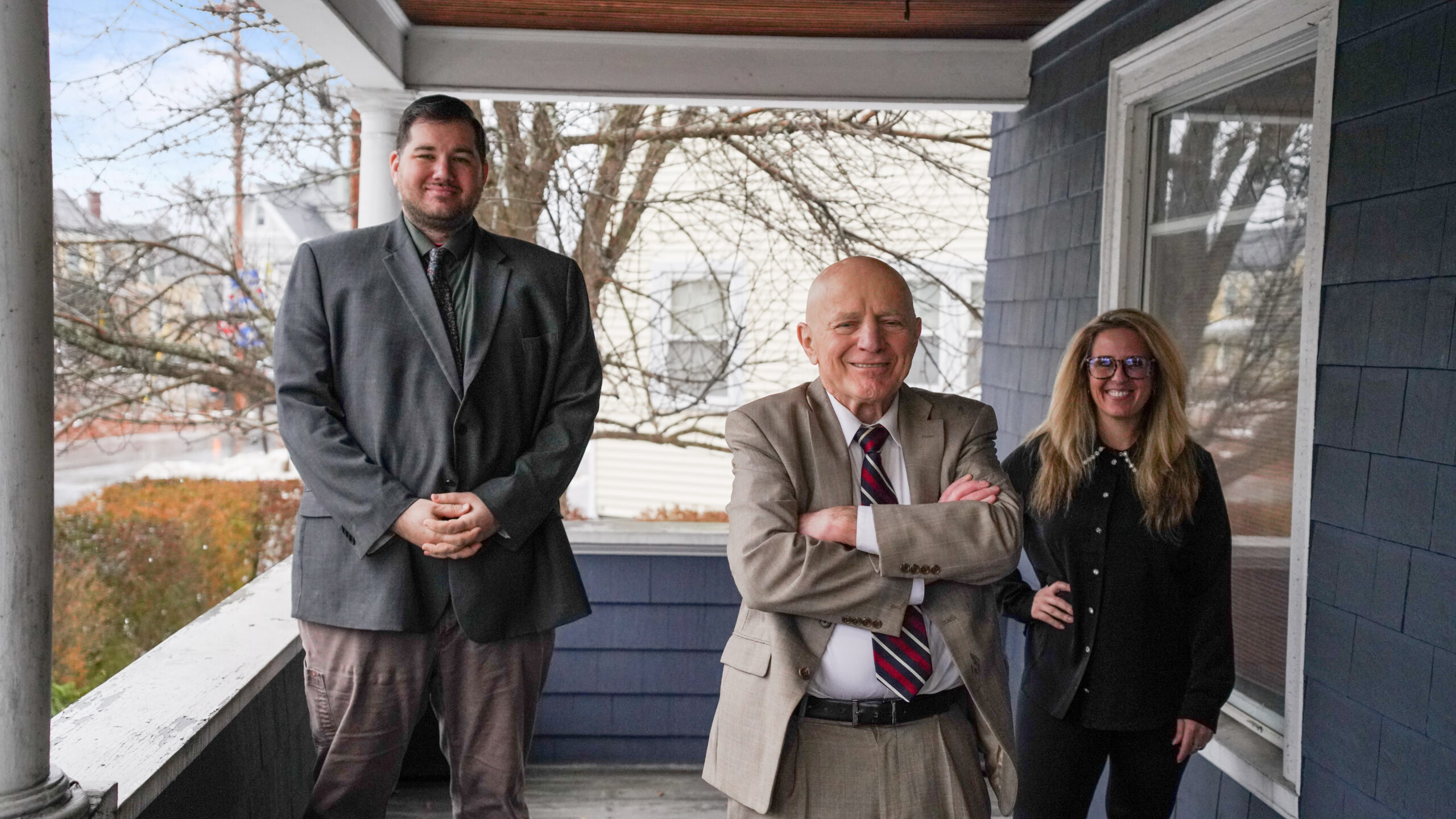 A group of four professionals, two men and two women, are gathered around a conference table reviewing printed charts and documents.